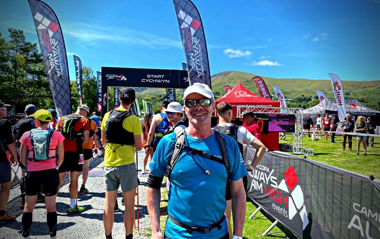 A trail runner smiling at the race start.