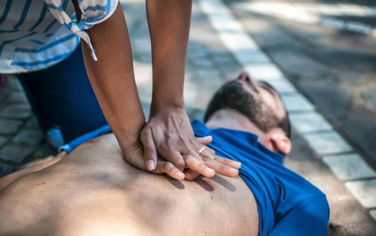 Good News: Cardiac Deaths In Marathons Are Dropping. Here's Why. 2 a person holding hands to a man's back