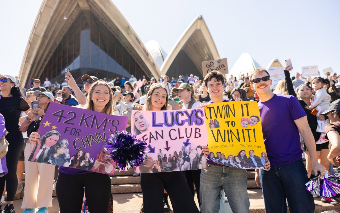 Marathon spectators holding sign. 