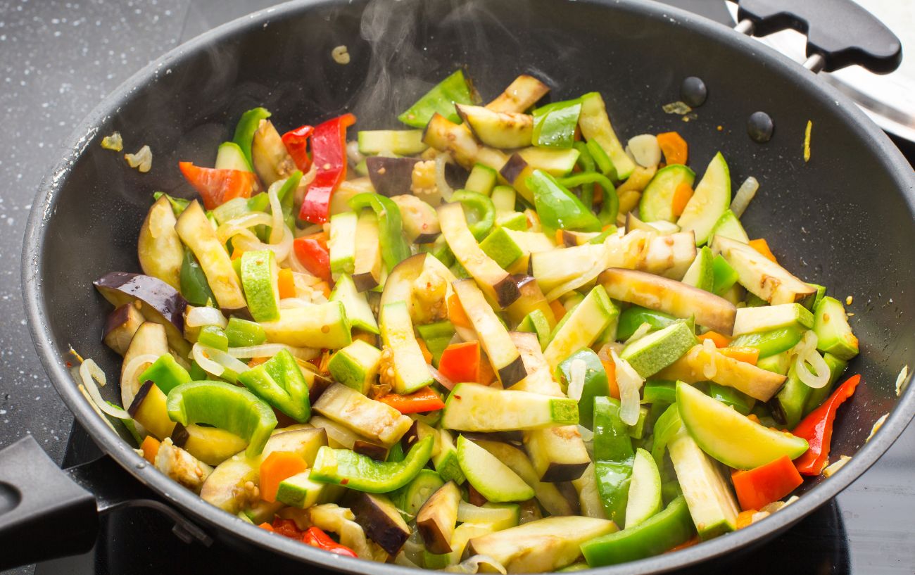 Una sartén de verduras cocidas.