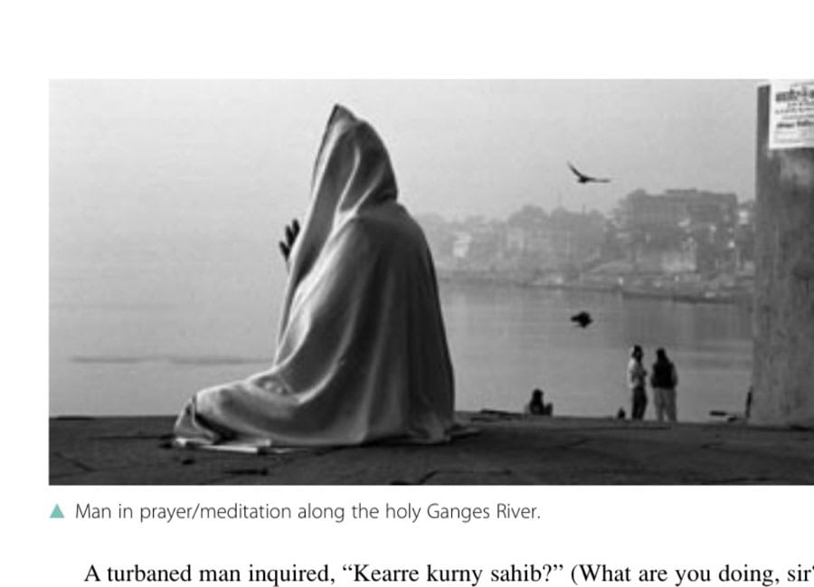 Man in prayer/meditation along the holy Ganges River.