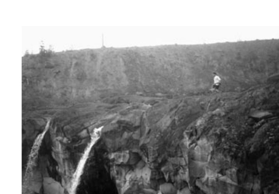 In a soupy fog, author Mike McQuaide runs past a waterfall at the bottom of one of Mount St. Helens's many gorges. Water is plentiful but mostly silty along the Loowit. Clean water is scarce.