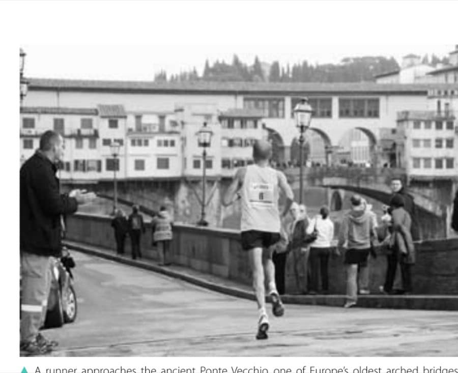 A runner approaches the ancient Ponte Vecchio, one of Europe's oldest arched bridges, which crosses the Arno River.