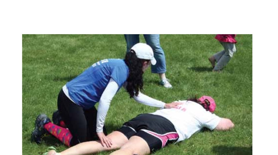 Post-race massage being administered to a runner lying on the grass. © Mark Hutchinson