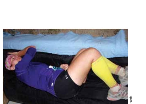 A runner lying down with legs elevated and compression garments applied. © Wayne Ebenroth