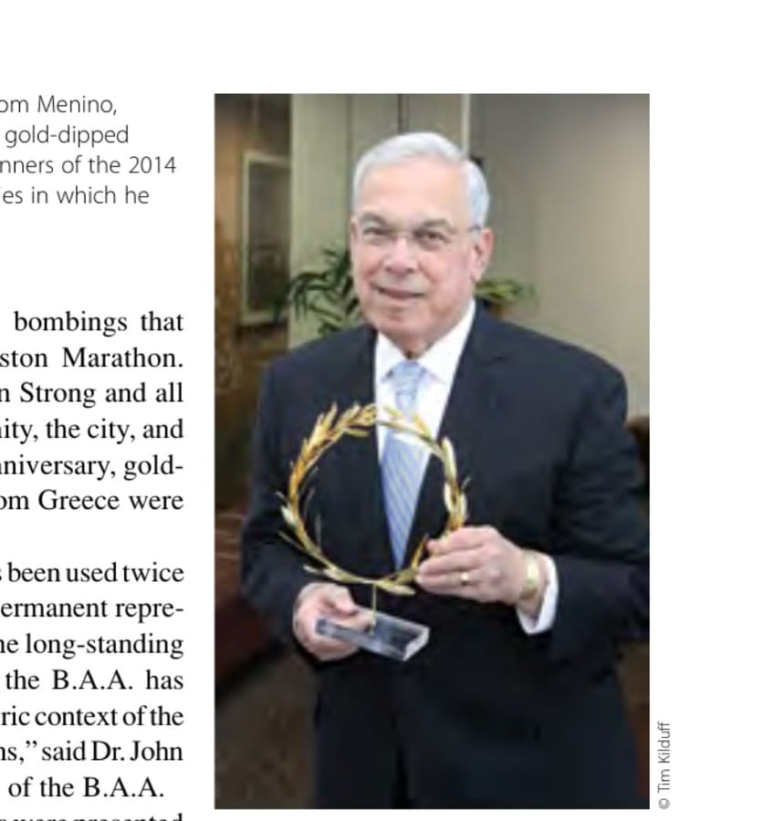 The late Boston mayor, Tom Menino, proudly holding one of the gold-dipped wreaths bestowed upon winners of the 2014 Boston Marathon, ceremonies in which he partook each year.