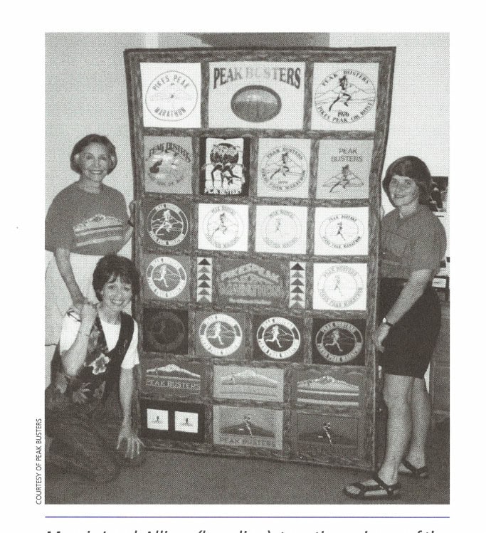 To the Peak 14 Margie Loyd-Allison (kneeling), two-time winner of the Pikes Peak Marathon, with Annabel Marsh (left) and Caroline Merrill (right), displays the quilt she made from her collection of Peak Busters T-shirts.