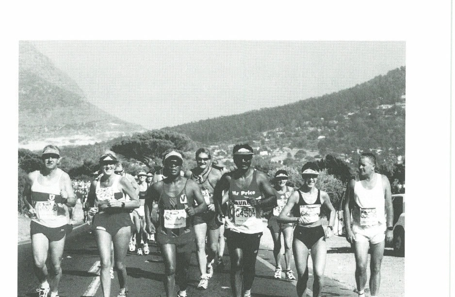 Two Oceans participants climbing Constantia Nek, with Hout Bay sand dunes in the background.