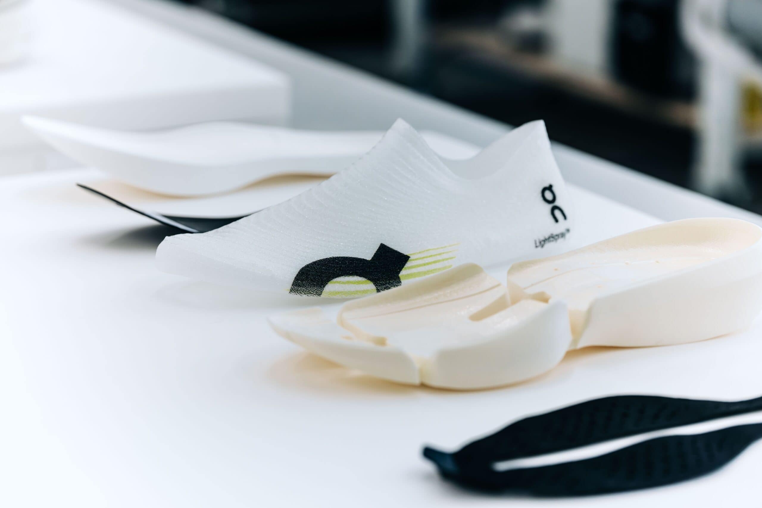 A LightSpray upper and midsole components laid out on a table