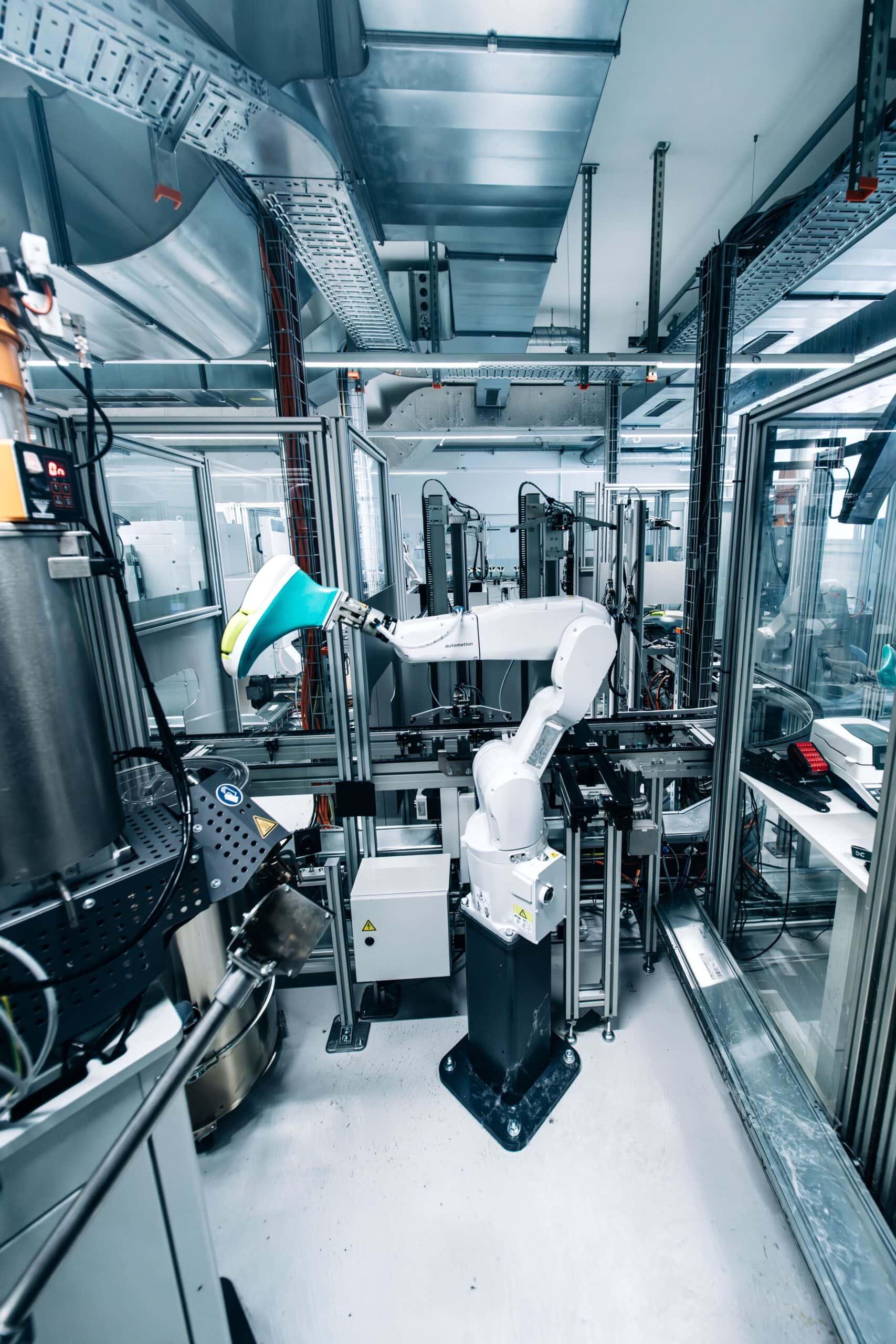 The LightSpray robot arm holding a last inside its enclosure at On headquarters in Zurich