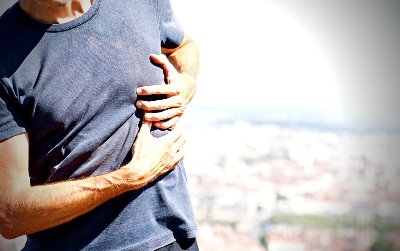 Una persona sosteniendo su costado debido a un calambre abdominal.