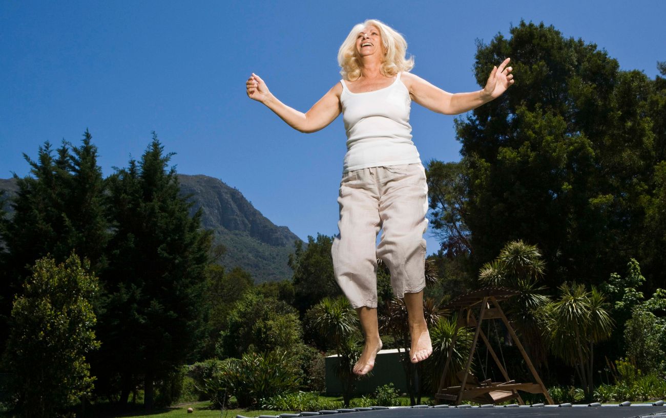 Una persona saltando en un trampolín al aire libre.