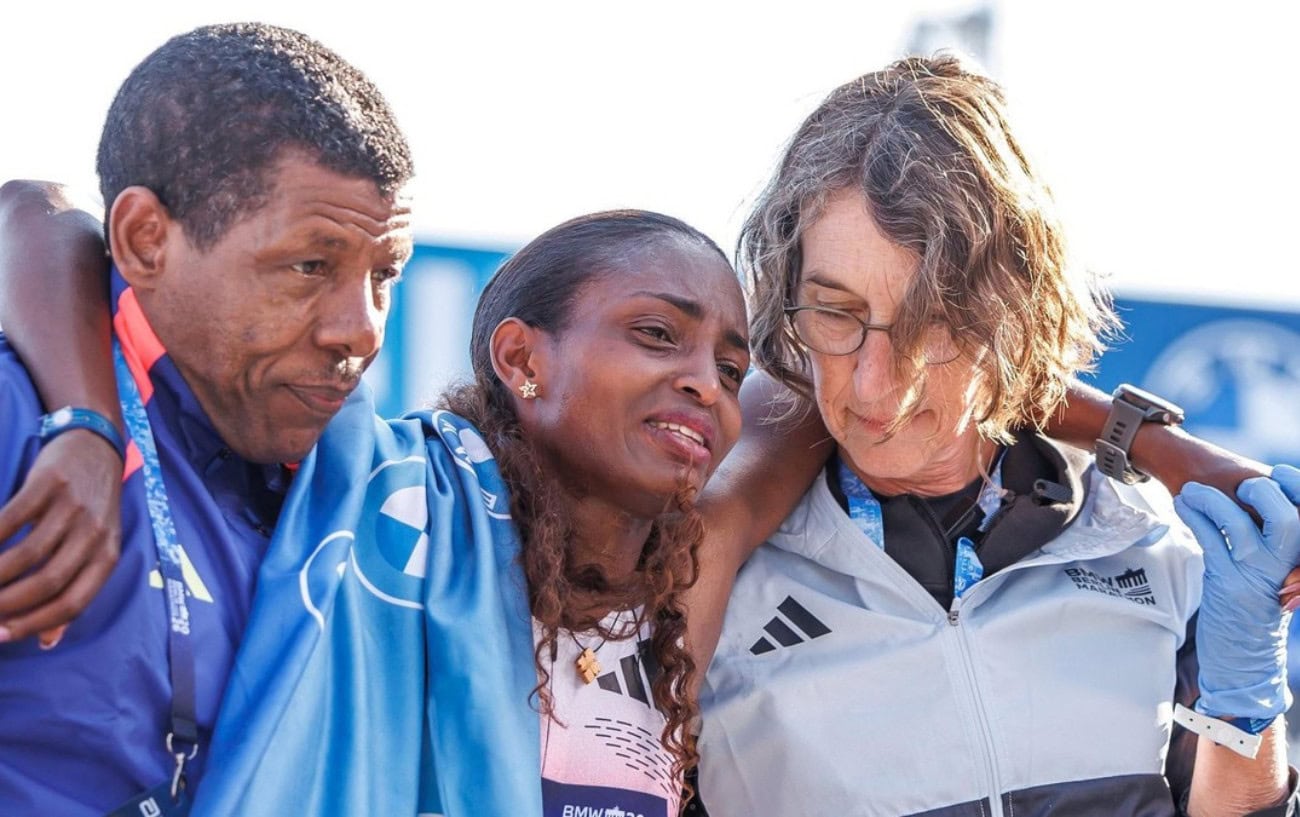 Haile Gebrselassie and a member of the medical team help Tigst Assefa after she finished the 2026 Berlin Marathon