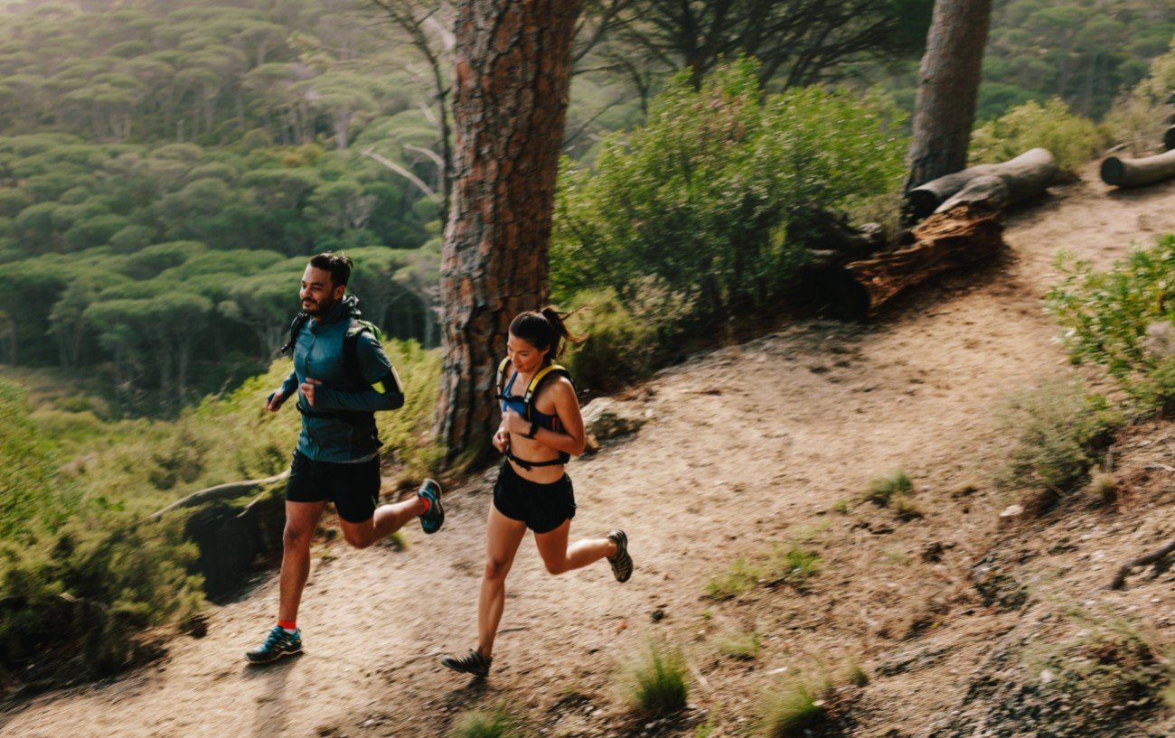 A man and woman running in the woods