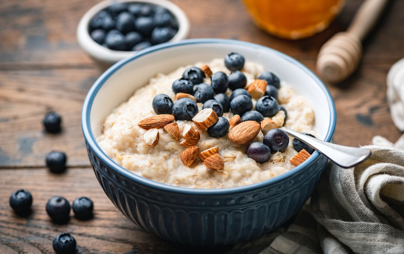 A bowl of oatmeal and fruit and nuts.