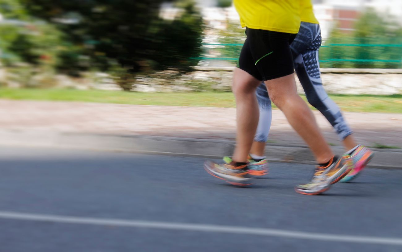 Dos personas corriendo en la carretera.