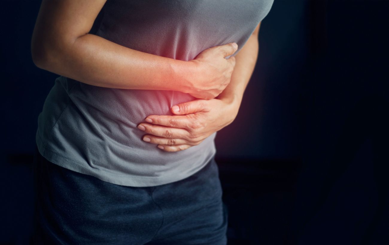 A person holding their stomach due to gas.