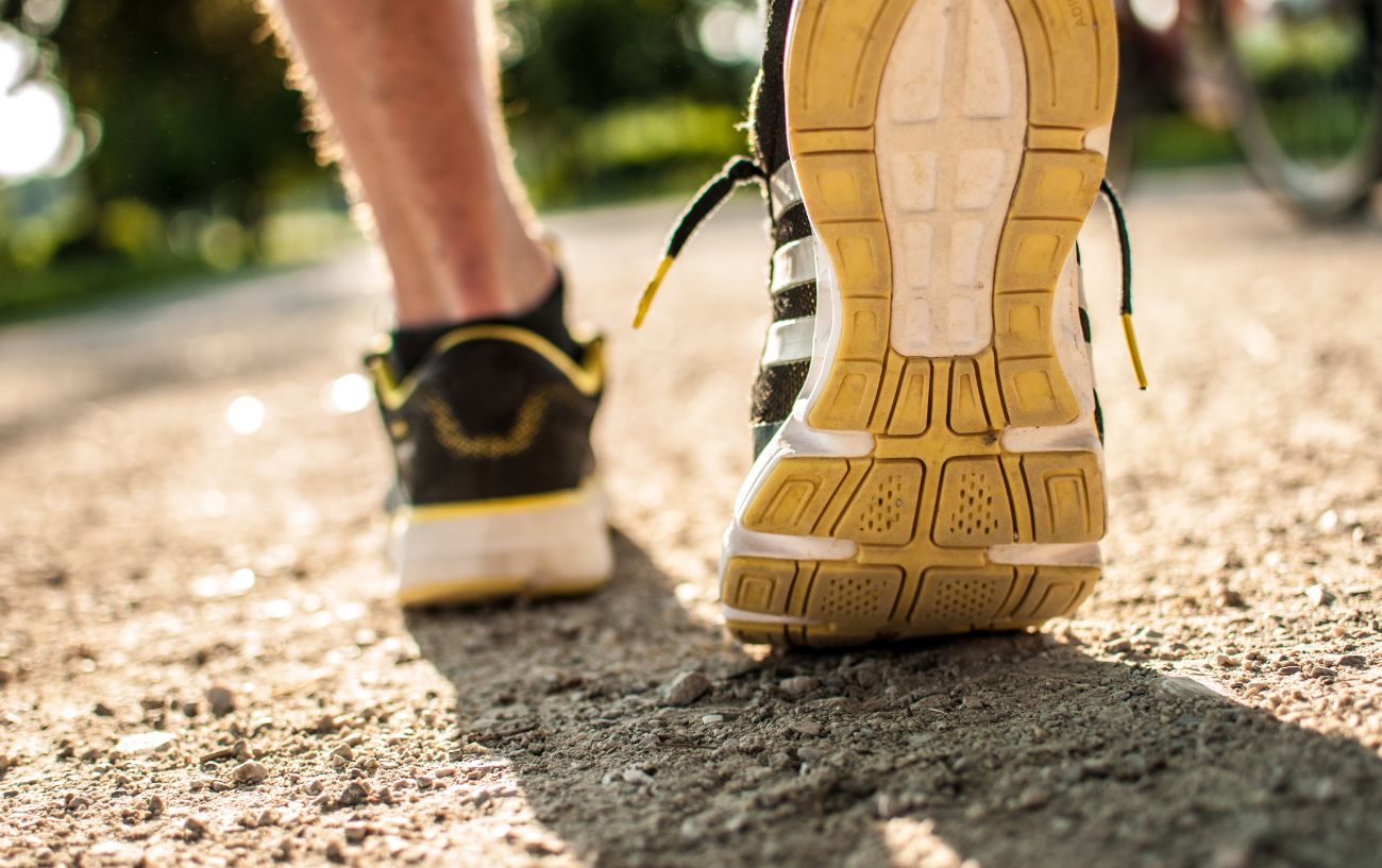 A person taking a step in running shoes.