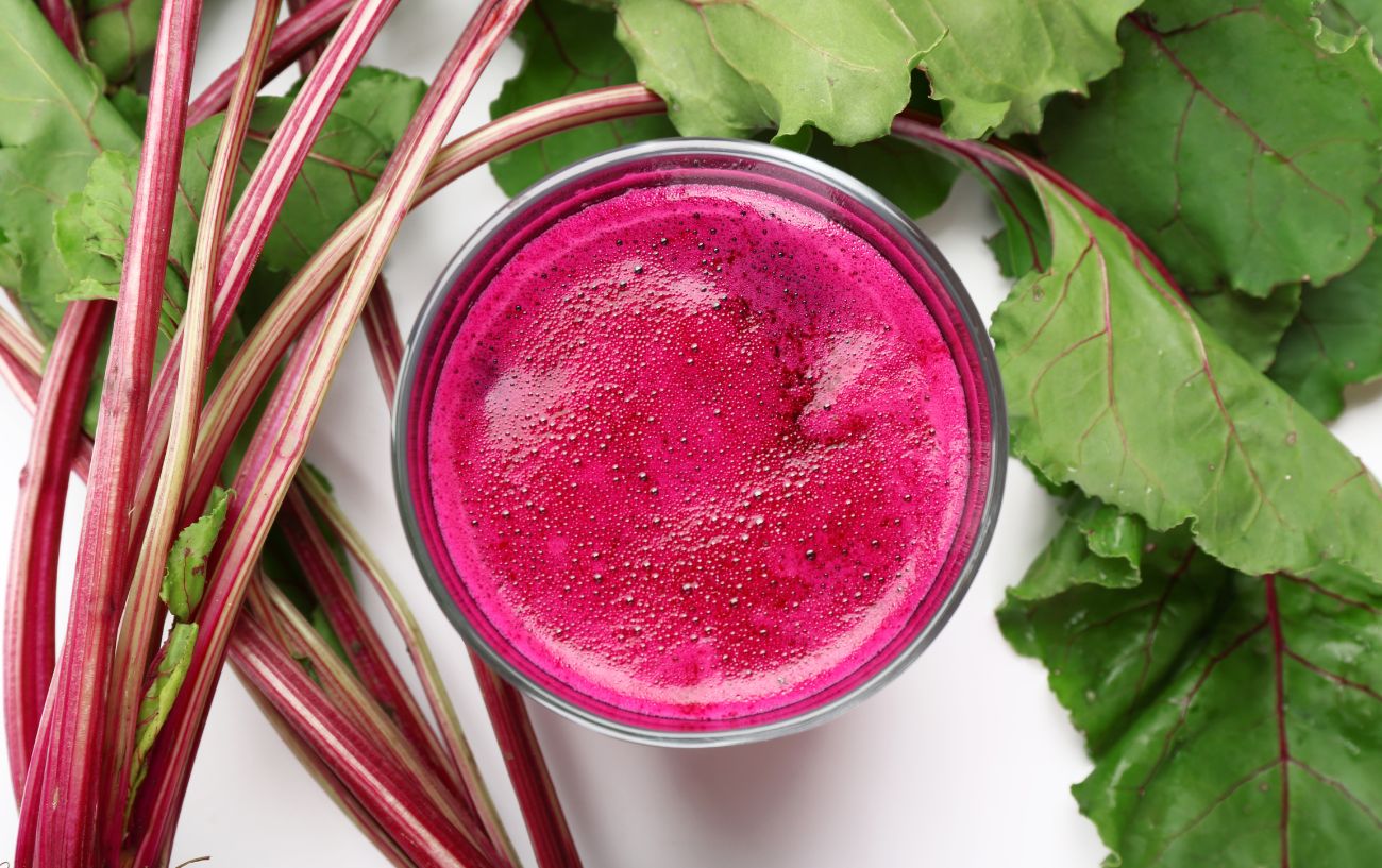 A glass of beet juice and beets.