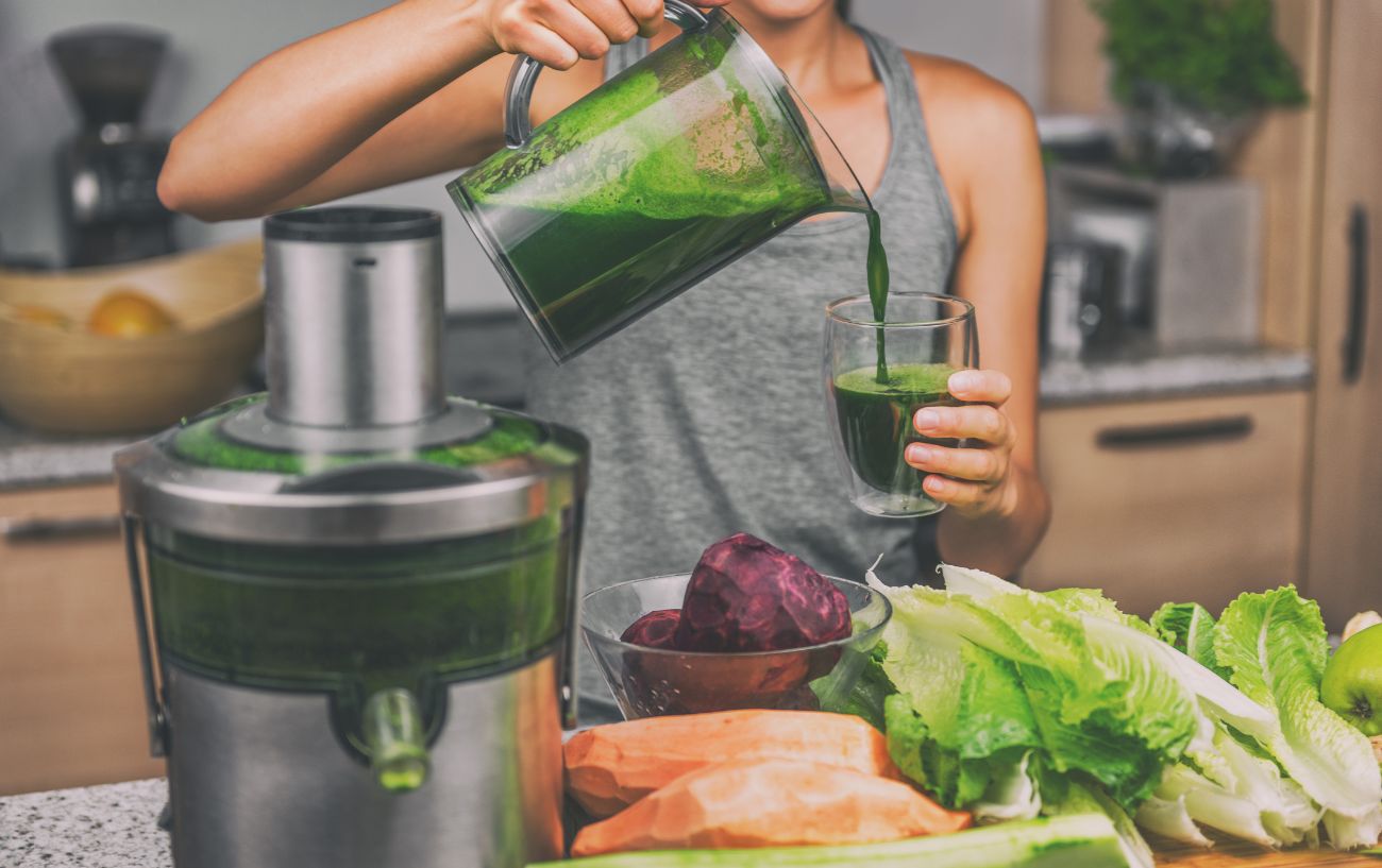 A person making a vegetable smoothie with beets and other vegetables.