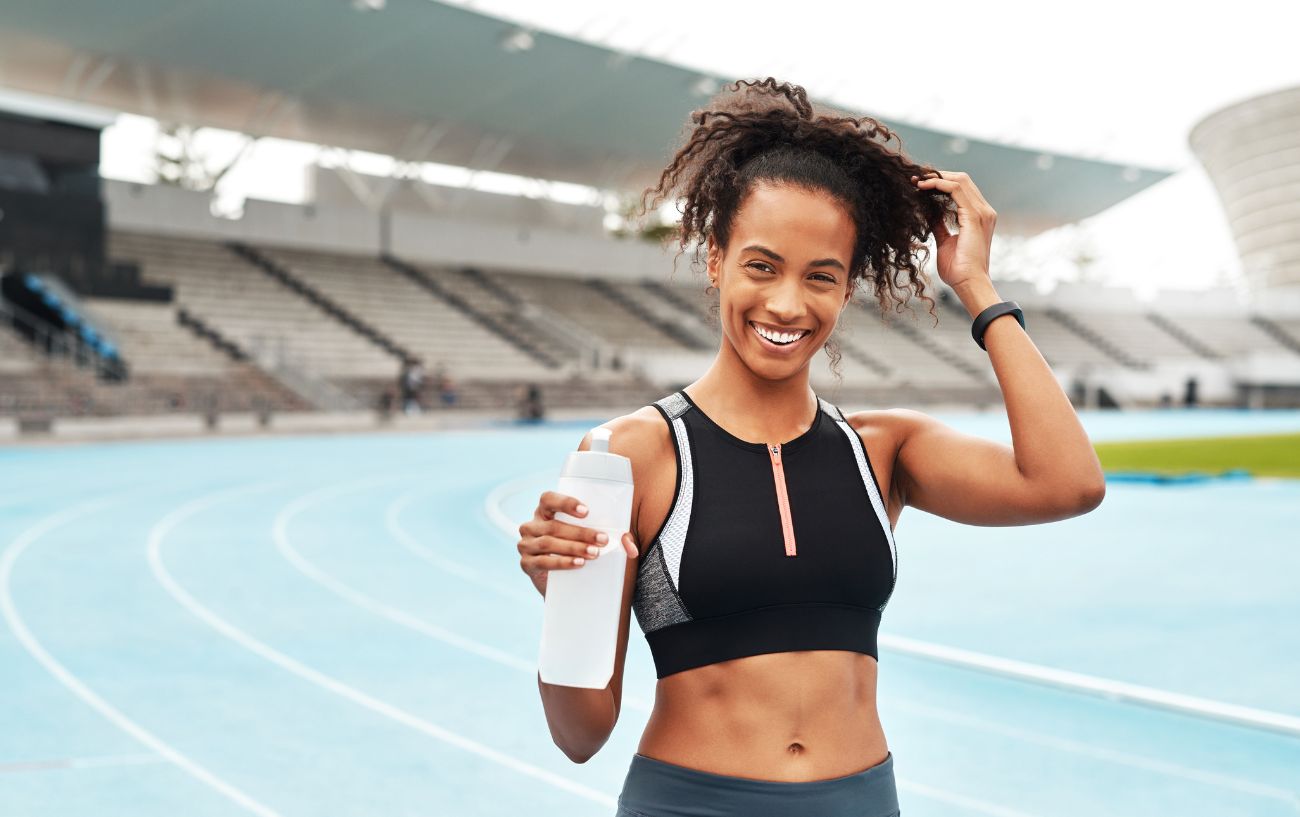 A person on a track with a water bottle.