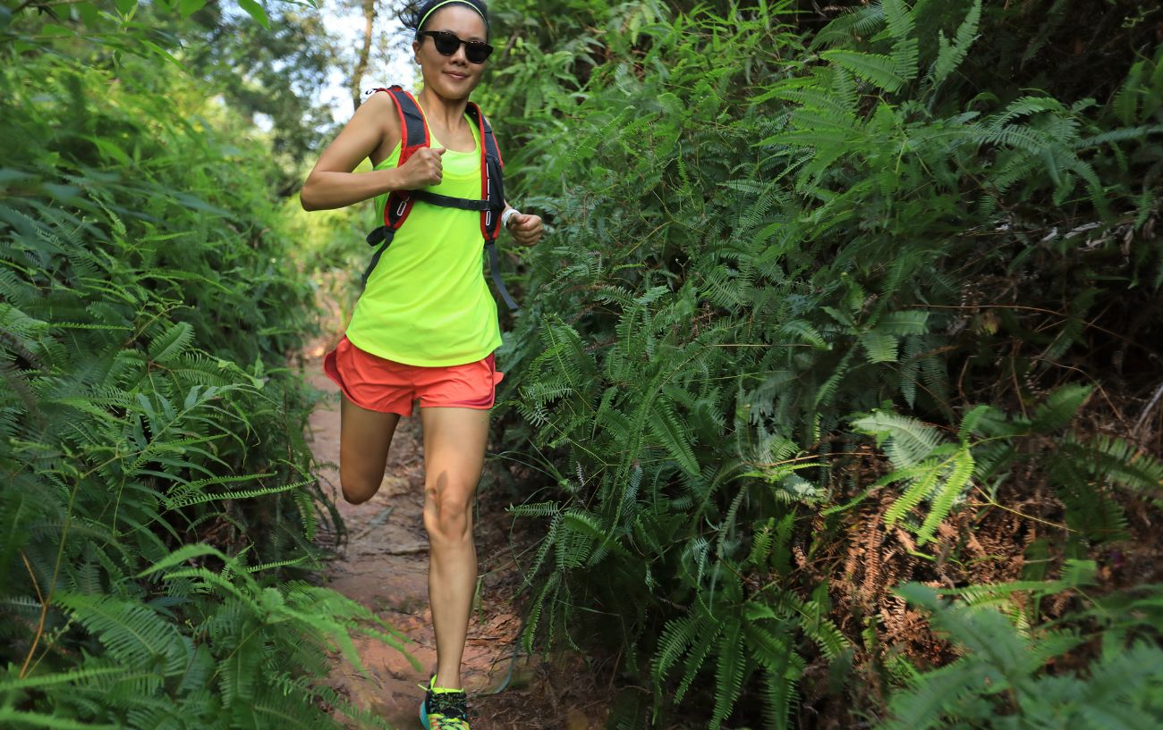 Una persona corriendo por senderos, entrenando para un ultramaratón.