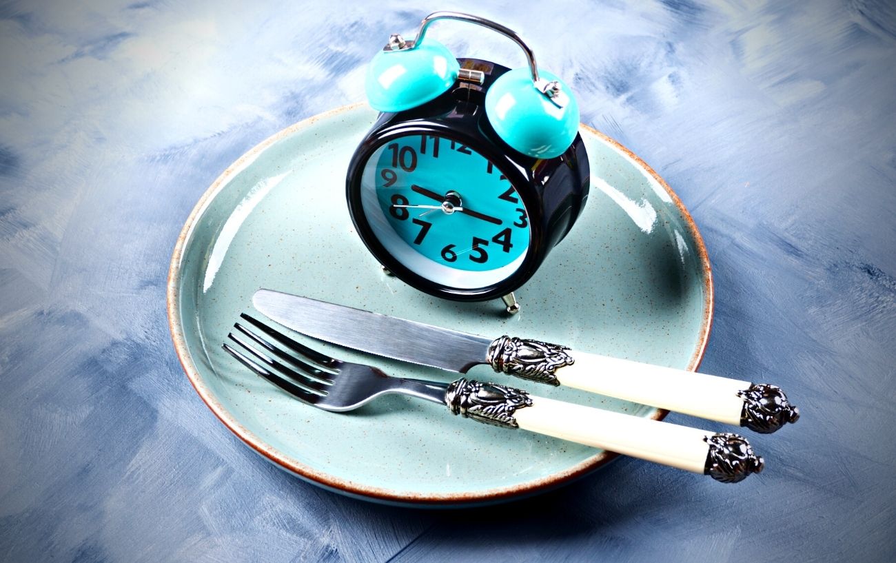 Un reloj y utensilios sobre un plato.