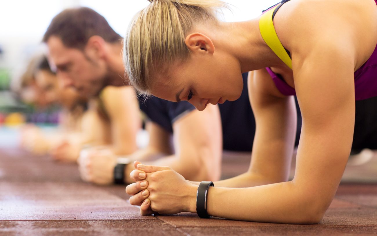 People doing planks in a gym class.