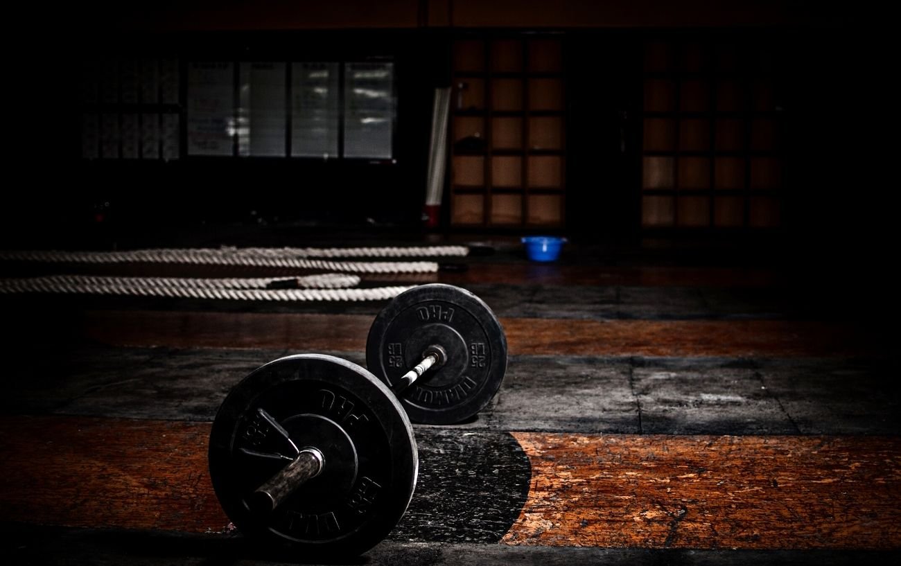 Una barra en el suelo de un gimnasio oscuro.