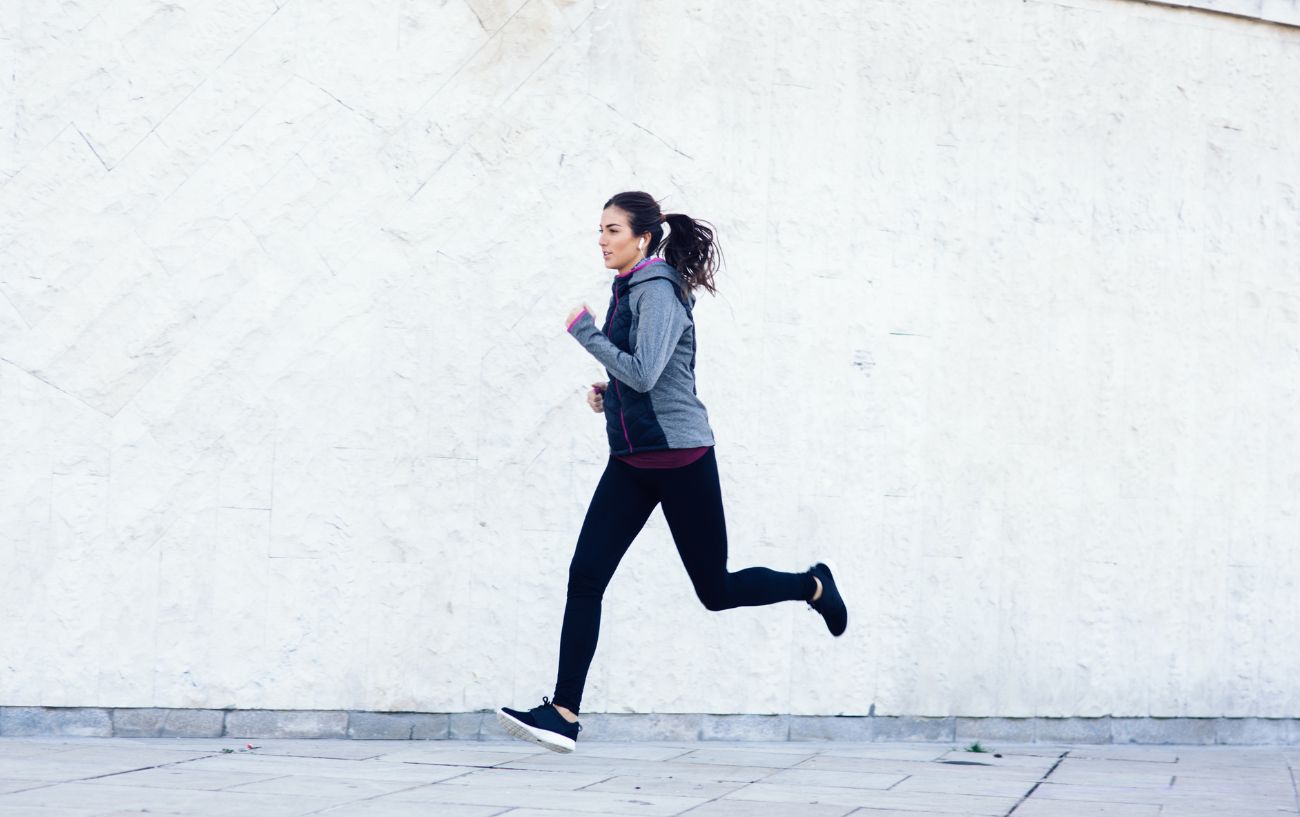 A person running on a tile walkway.