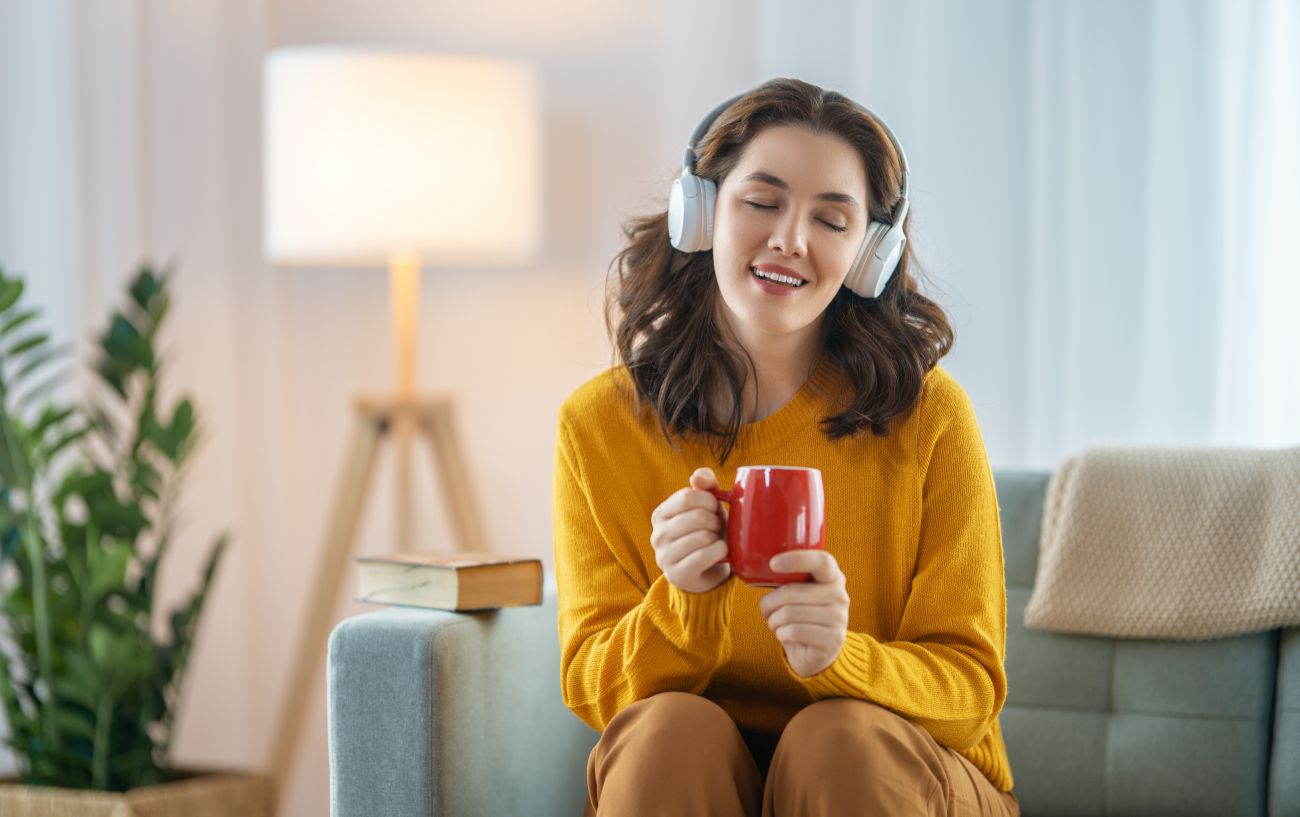 How To Increase Dopamine Levels To Boost Your Mood + Motivation: 9 Ways 8 A person listening to music and smiling.