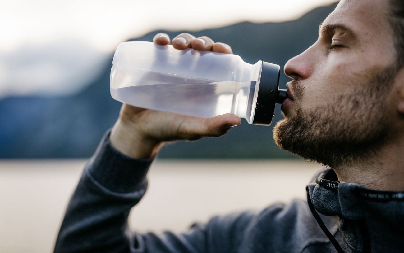 How Western States Runners Will Beat the Heat: 11 Science-Backed Cooling Strategies 2 a man drinking from a bottle