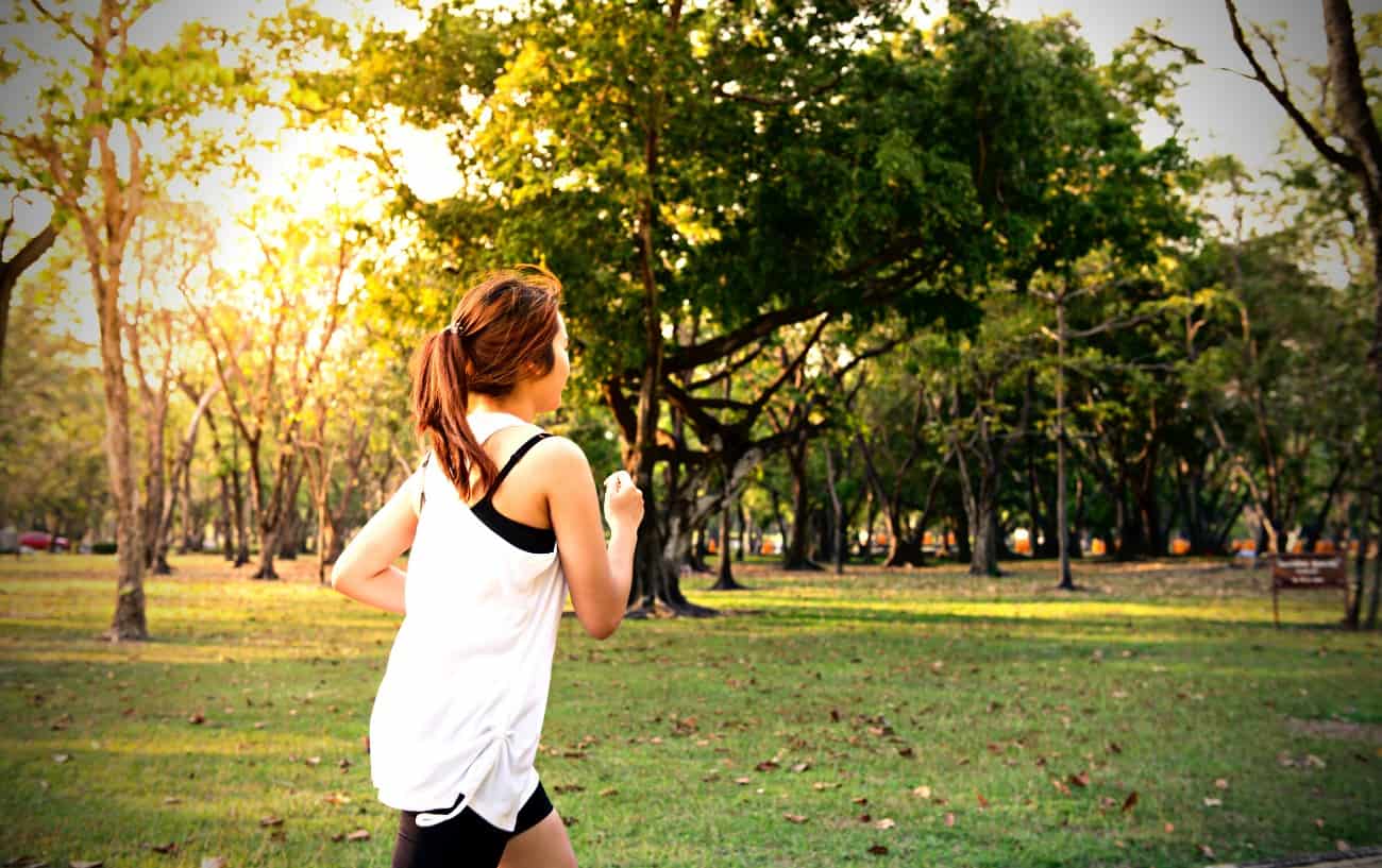 How To Improve Running Form: 29 Ways To Run More Efficiently 5 A person running in a park.