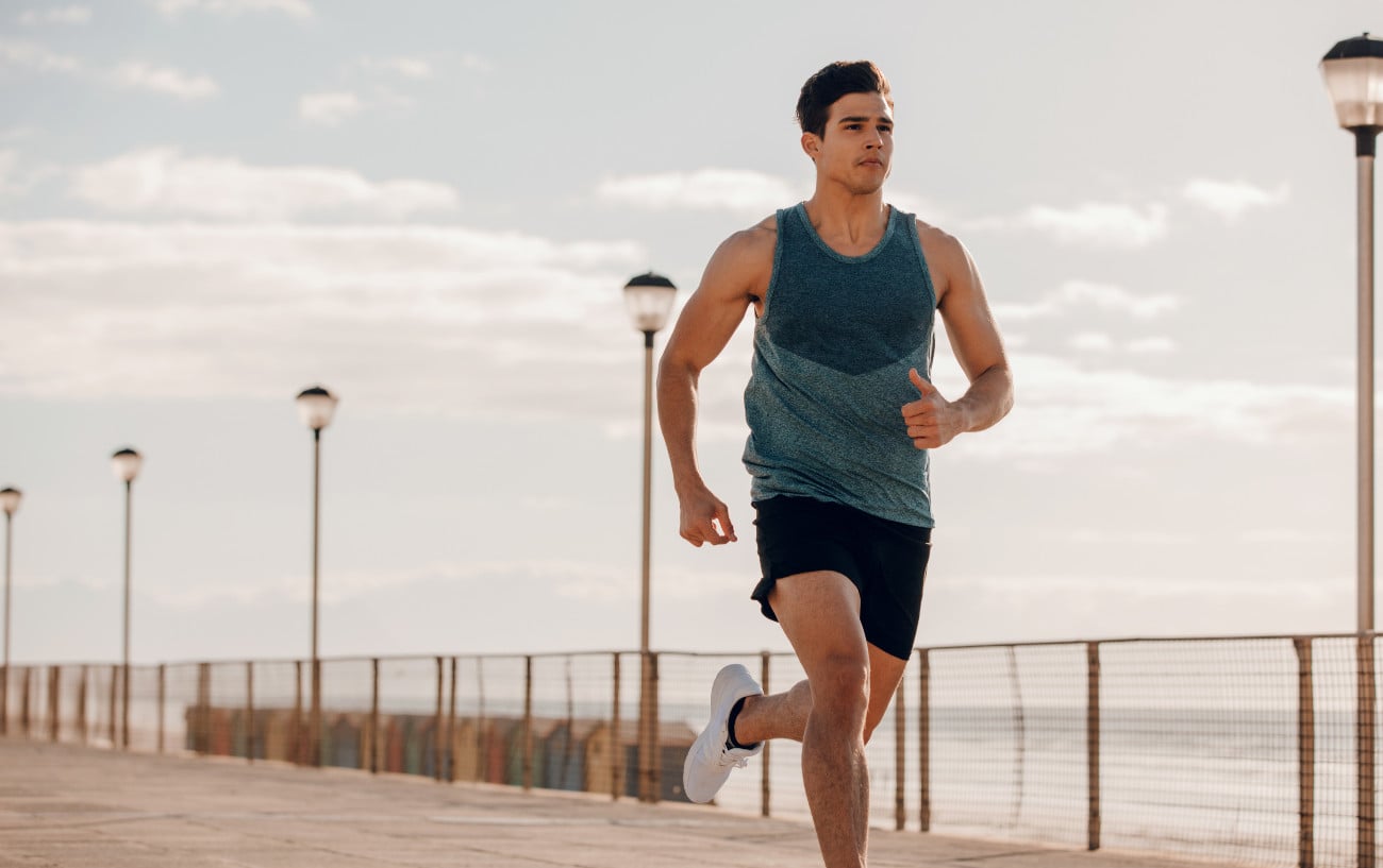 How To Prepare For A Half Marathon: 12 Top Tips From Our Expert Coach 1 A man running on the coast.