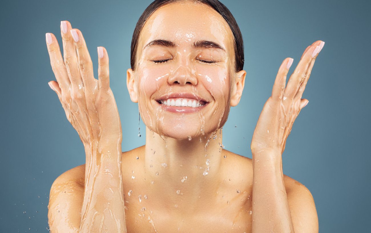 A person splashing water in their face.