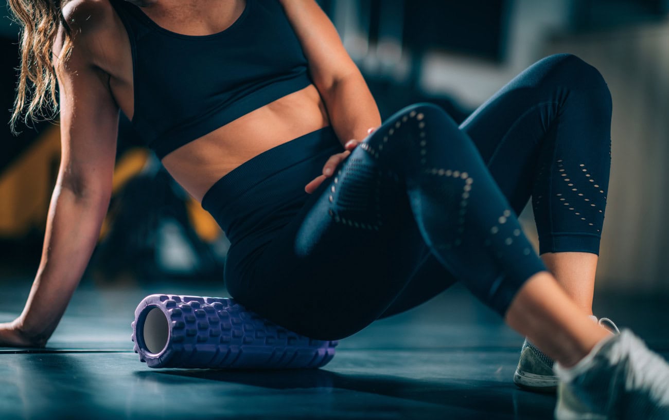 Marathon Training Recovery: How To Recover Quickly After Workouts 2 woman foam rolling her glute.