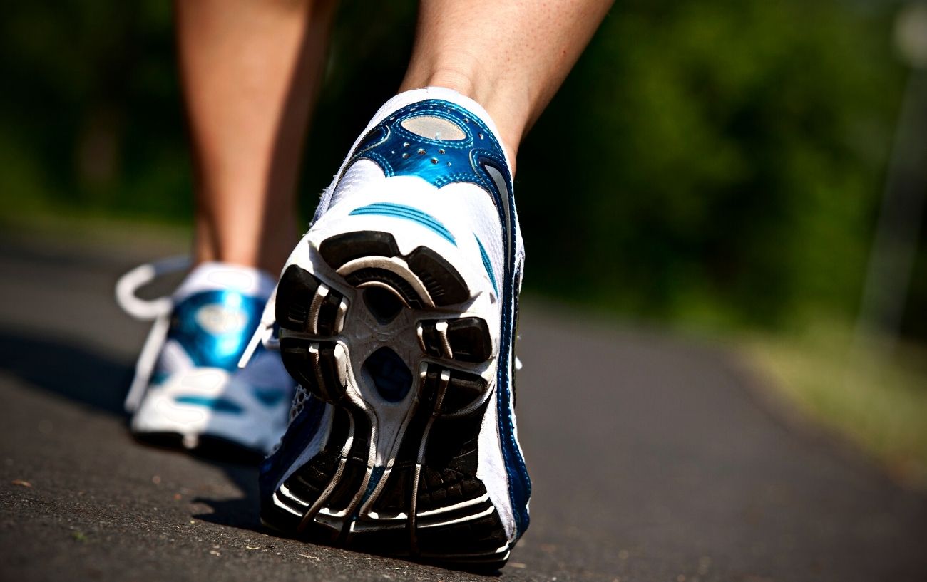 A close-up of the tennis shoes of someone walking.