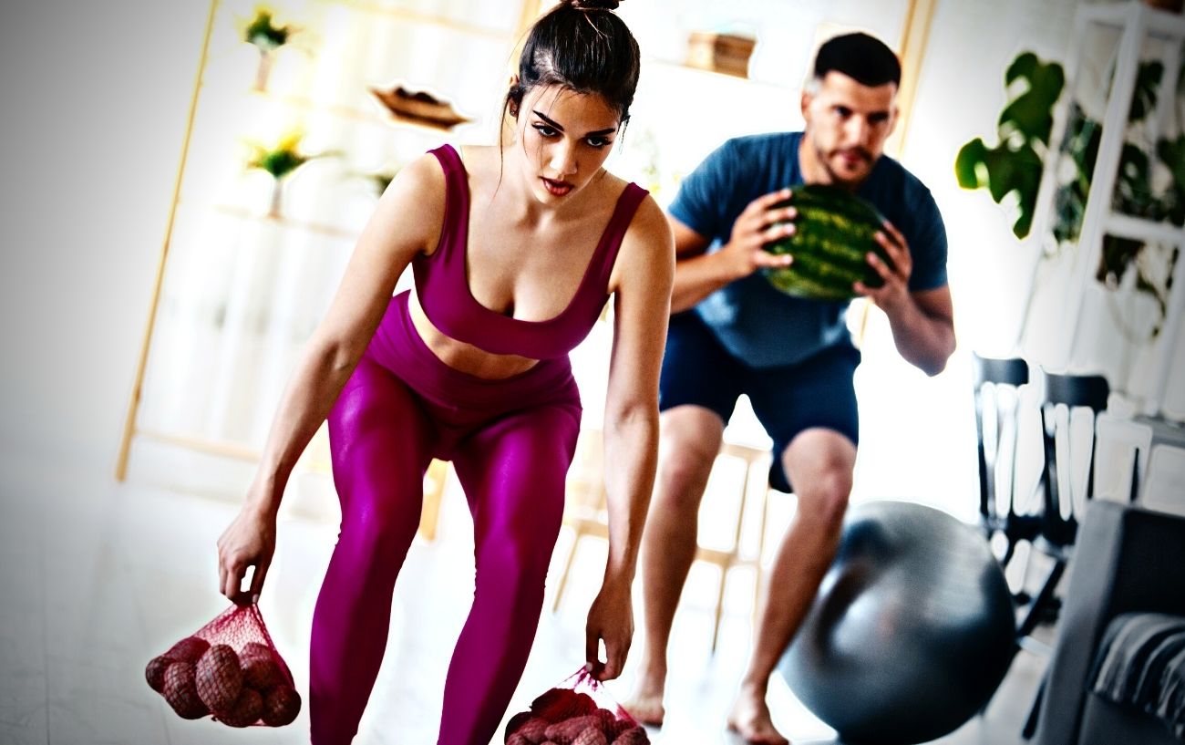 People working out at home carrying fruit at weight.