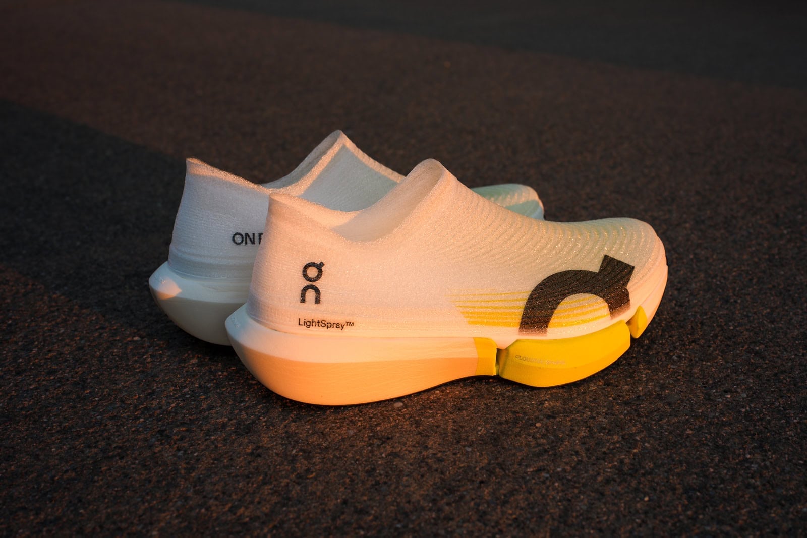 The On LightSpray Cloudboom Strike 2 in profile on asphalt