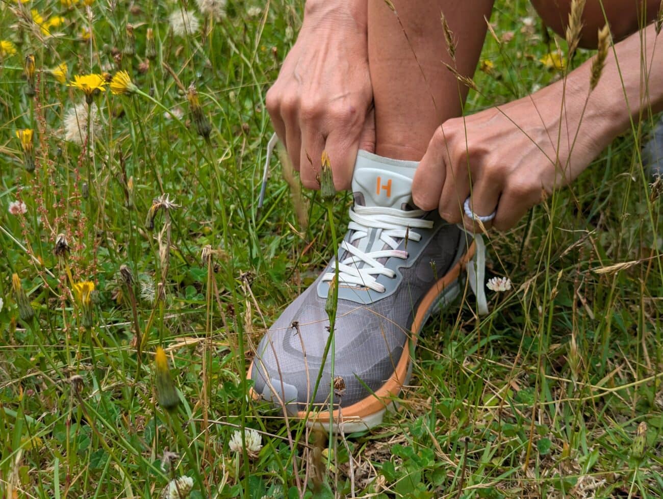 Running Shoe Review: Hettas Alma Tempo – Made for Women, by Women 2 Person tying shoelaces in grass