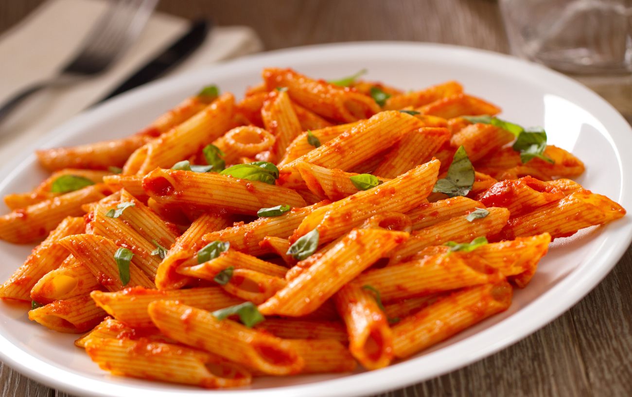 A plate of pasta with tomato sauce.