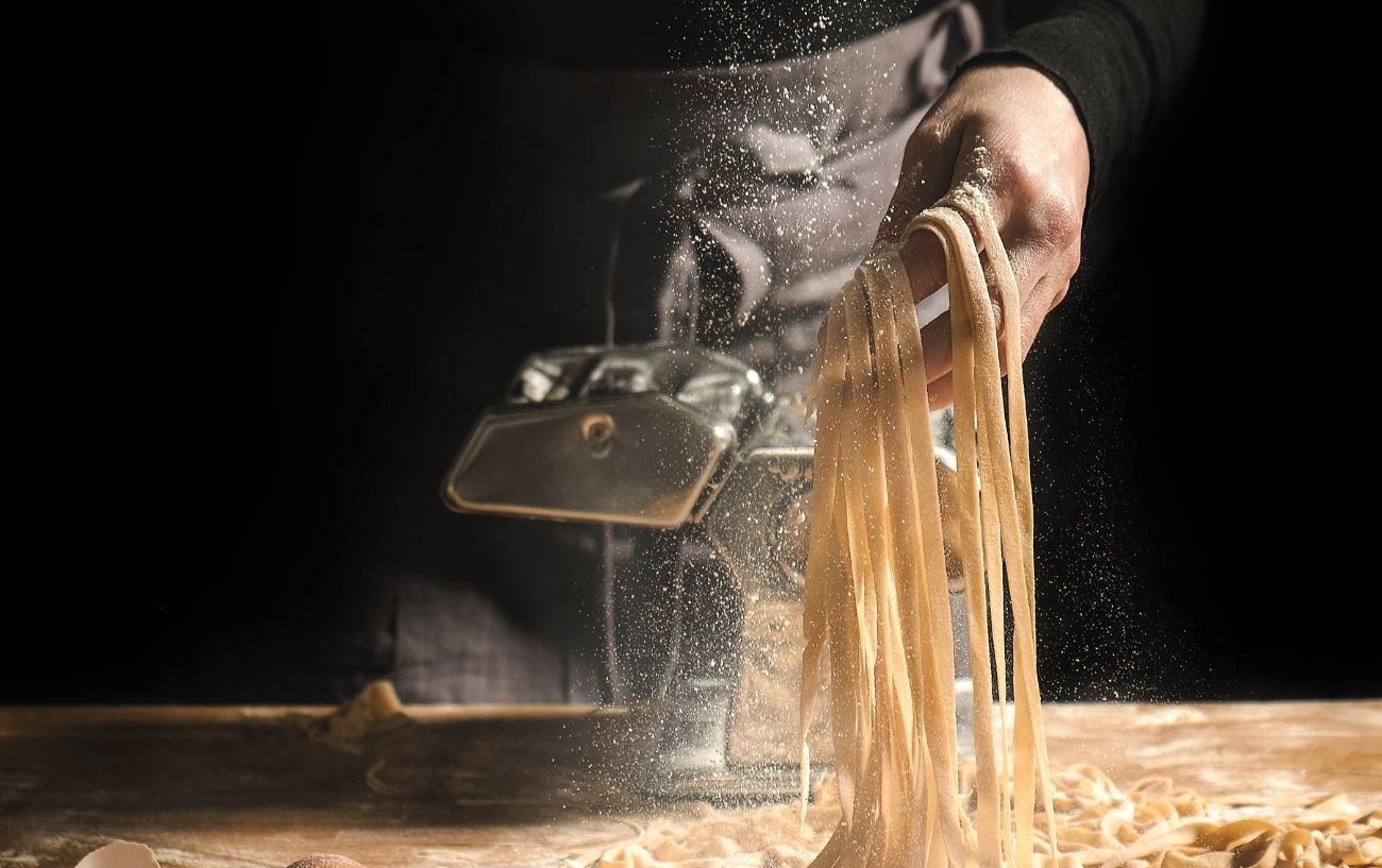 Homemade pasta is being put through the machine.