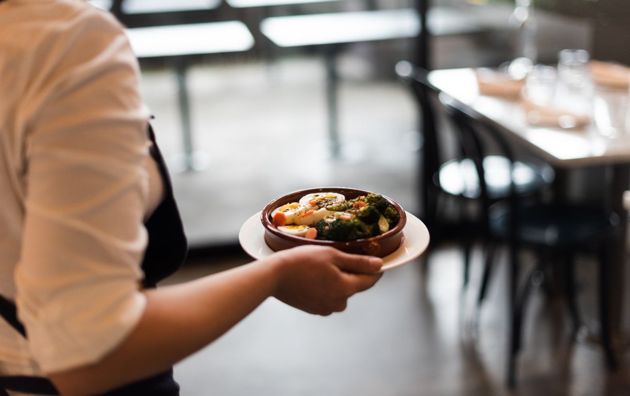 A waiter carrying a plate of food.