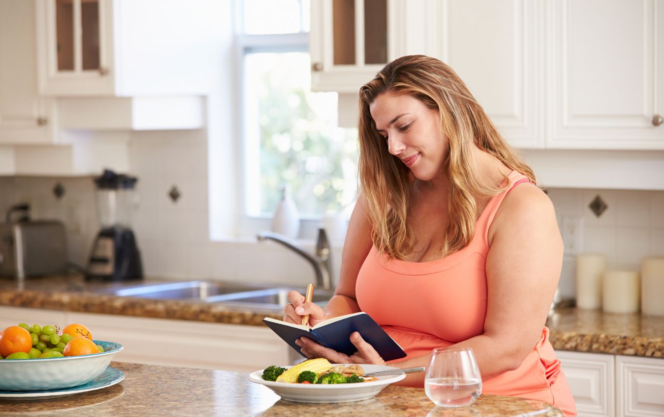 A person writing in a food diary.