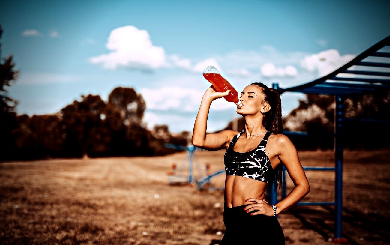 Una persona bebiendo una bebida deportiva.