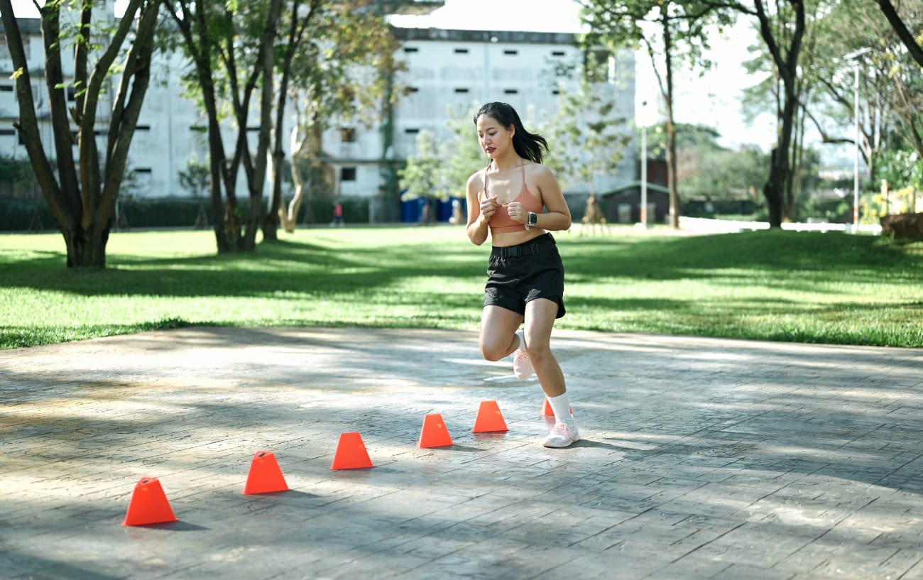 A runner doing drills with cones.
