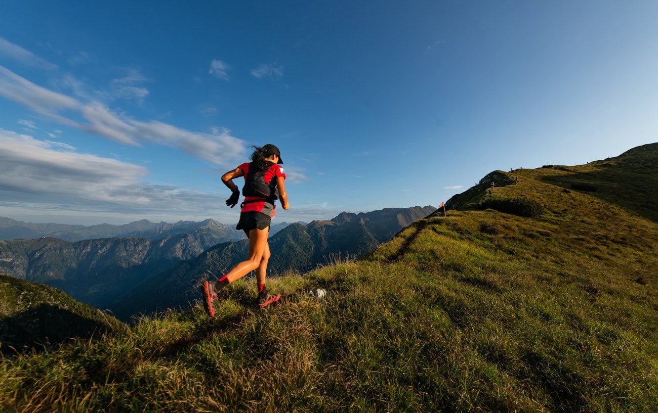 A trail runner running up a mountain.