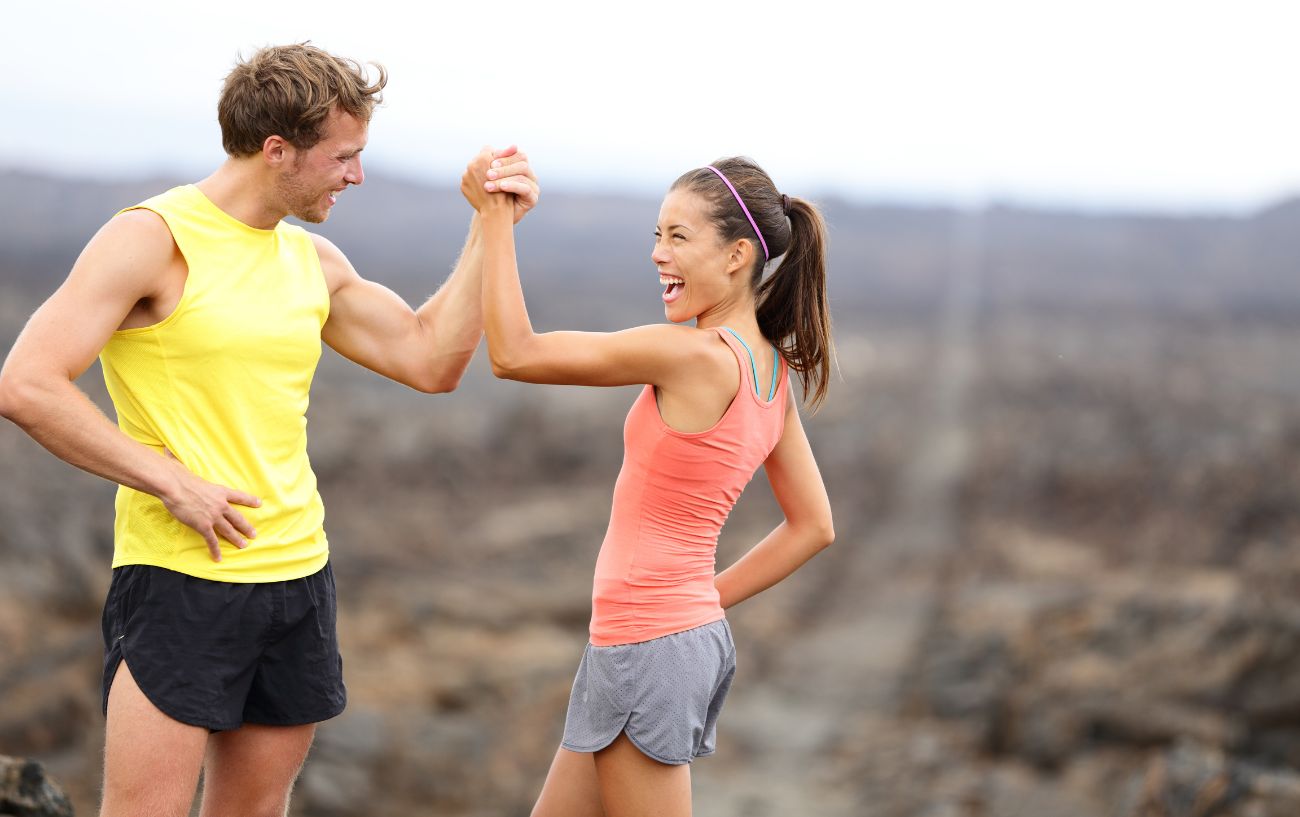 Two runners smiling and giving each other a high-five.