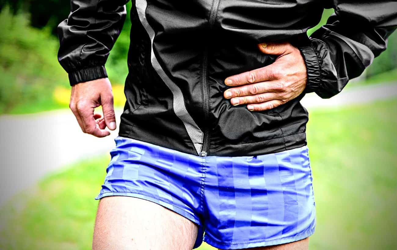 A runner holding their stomach in pain.