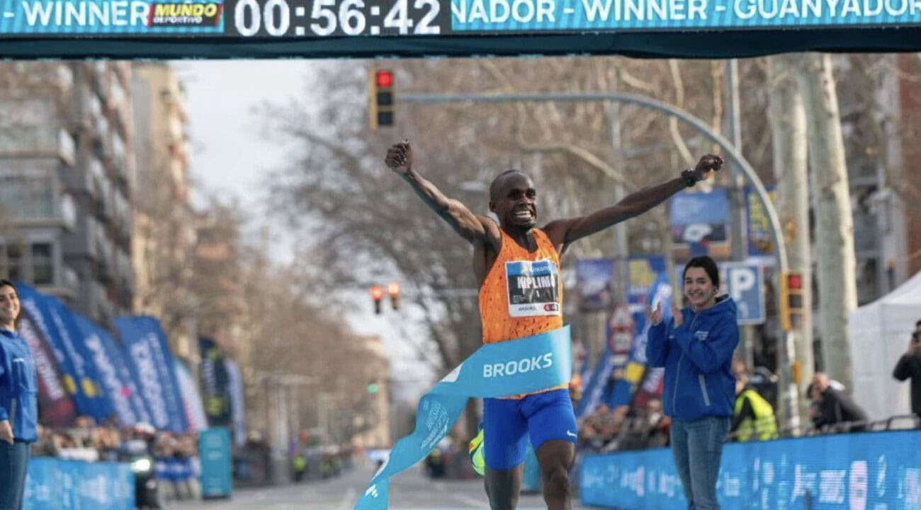 Runner celebrating victory at finish line.